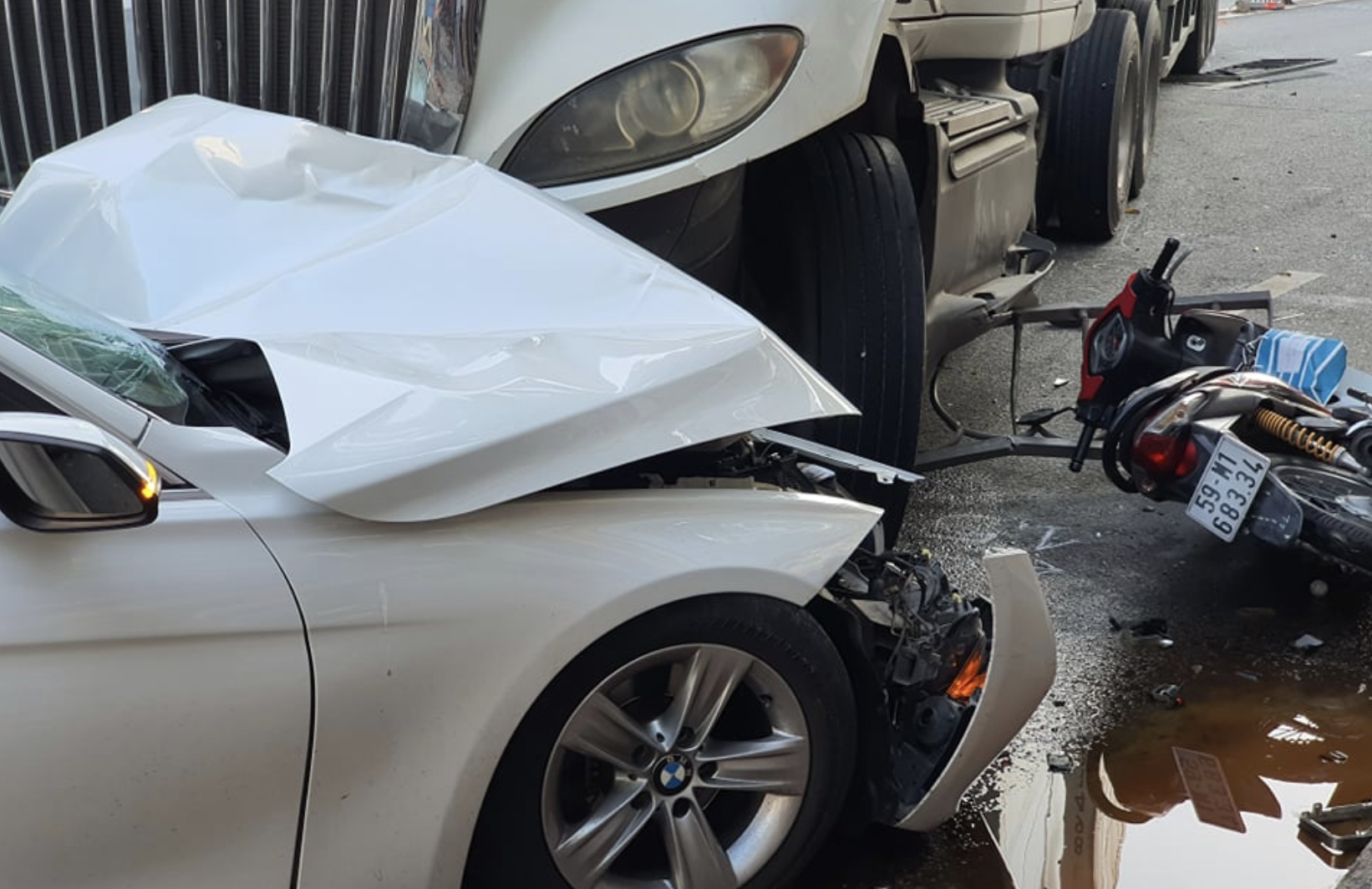 TP.HCM: Xe container mất lái lao vào dãy phân cách, húc nát đầu ô tô rồi cuốn nhiều xe máy vào gầm - Ảnh 1.