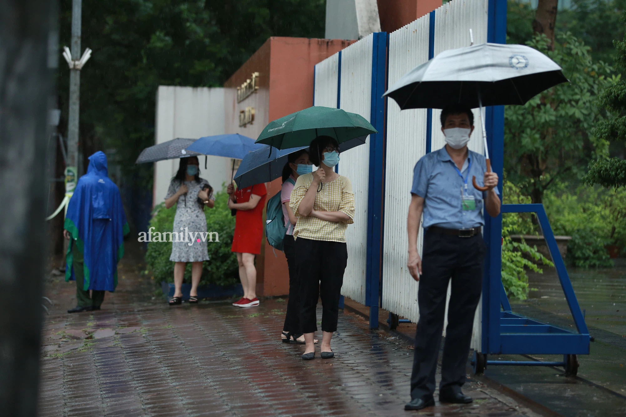 Mưa lớn như trút nước sáng 12/6, phụ huynh Hà Nội xách dép, đội mưa đưa con đi thi vào lớp 10 - Ảnh 10.