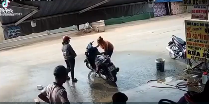 Mải nhìn điện thoại, thanh niên xe máy tông thẳng vào 2 phụ nữ đang rửa xe, hành động sau đó càng gây bức xúc - Ảnh 2.