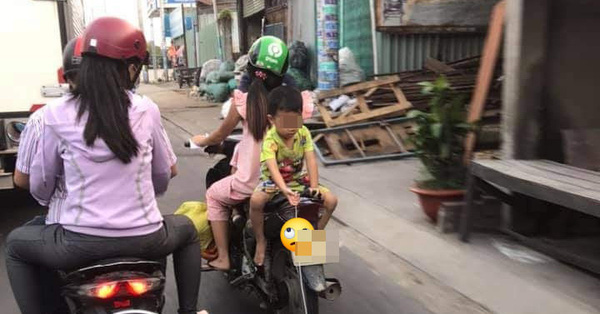 Hình ảnh gây phẫn nộ: Mẹ để con trai ngồi ngược khi xe máy đang chạy, mặc kệ xe tải kề bên