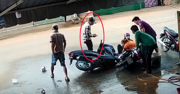 Thanh niên đi xe máy mải xem điện thoại, tông thẳng vào 2 phụ nữ đang rửa xe