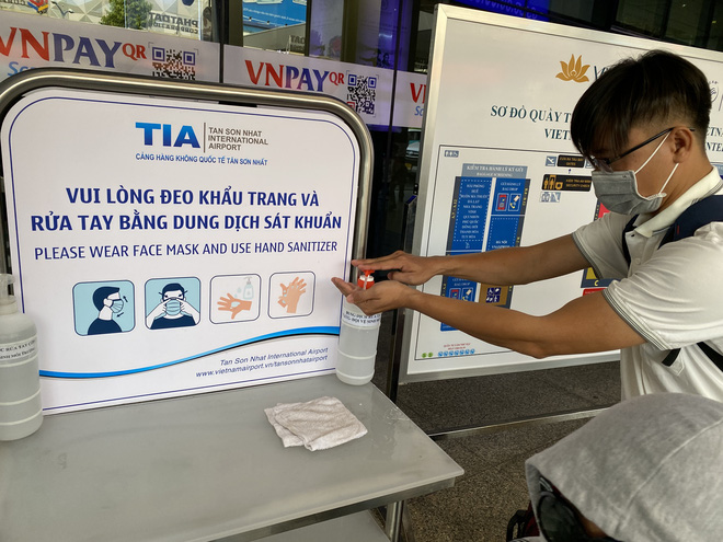 Hành khách xếp hàng dài ở sân bay Tân Sơn Nhất để đổi trả vé Tết vì dịch Covid-19 - Ảnh 9.