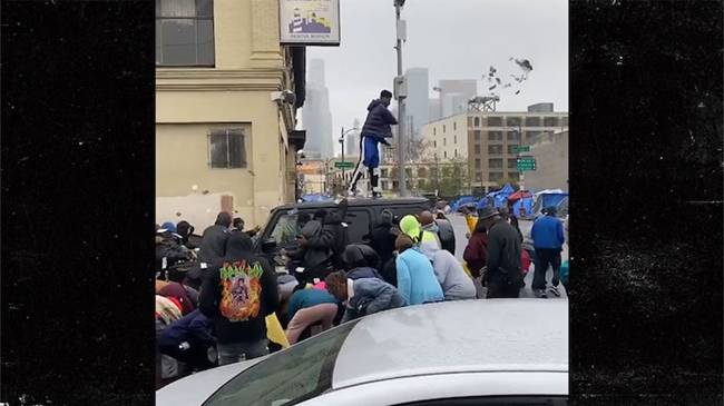 Lúc xảy ra sự việc ở Los Angeles (Mỹ), Rapper này trèo lên nóc ô tô rồi rải tiền xuống đường. Hàng chục người vô gia cư thi nhau nhặt.