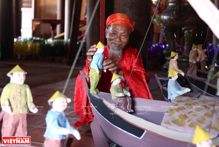 An elder prepares paper puppet for the ritual (Photo: VNA)