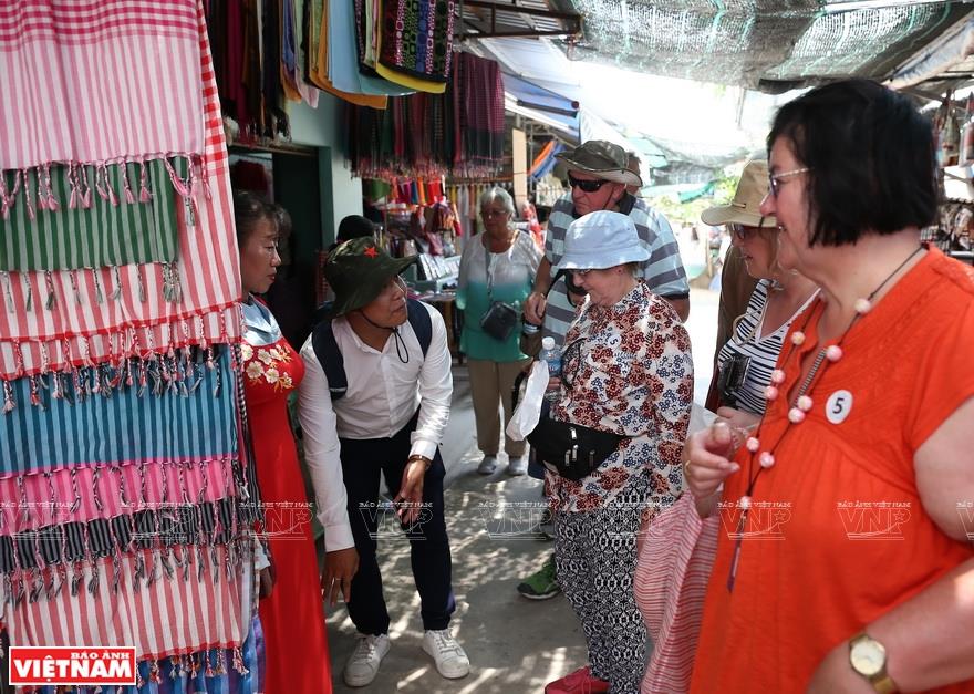 Foreign tourists enjoy the local produce and souvenirs on Thoi Son islet (Photo: VNA)