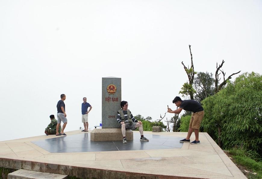 Tourists visit and pose for photos at Border Marker Zero (Photo: VNA)