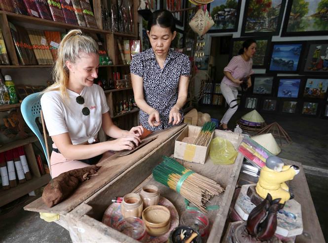 Tourists experience making incense in Thuy Xuan village (Photo: VNA)