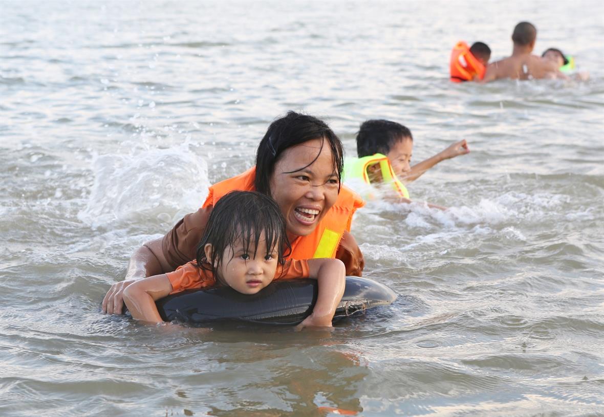 A mother is teaching her kid how to swim (Photo:VNA/VNP)