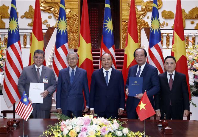 Prime Minister Nguyen Xuan Phuc and Malaysian Prime Minister Mahathir Mohamad witness the ceremonial signing of a Letter of exchange between the President of the Malaysia House of Representative and the Chairwoman of the National Assembly of Vietnam on the establishment of the Malaysia-Vietnam Friendship Parliamentary Group (Photo:VNA)