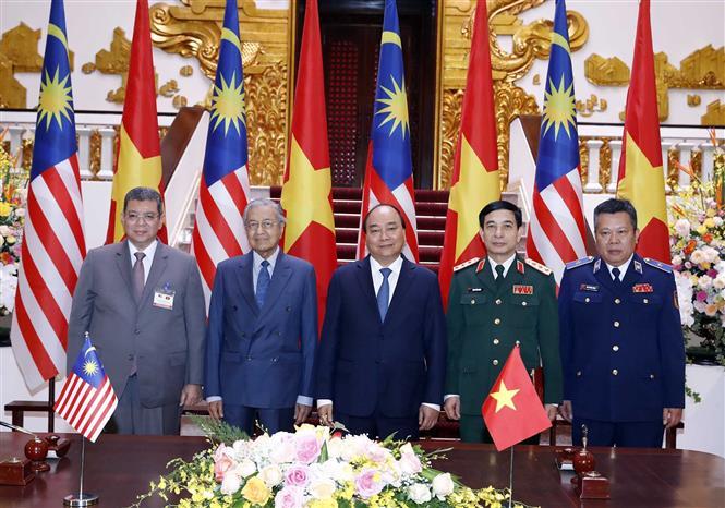 Prime Minister Nguyen Xuan Phuc and Malaysian Prime Minister Mahathir Mohamad witness the signing ceremony of a Letter of Intent on a Memorandum of Understanding between Vietnam and Malaysia on cooperation on law enforcement and search and rescue at sea (Photo:VNA)