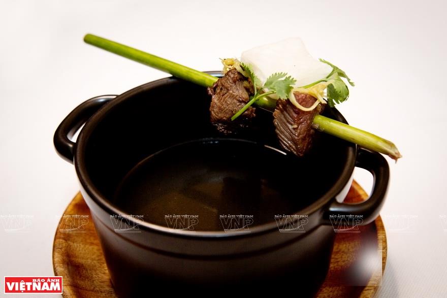 Soup served with grilled beef and ginger-flavored fried rice noodle (Photo: VNA)