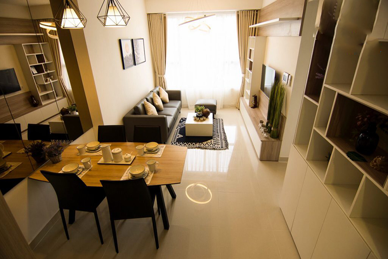 Một góc căn hộ chung cư với bộ bàn ăn kê cạnh bộ ghế sofa phòng khách