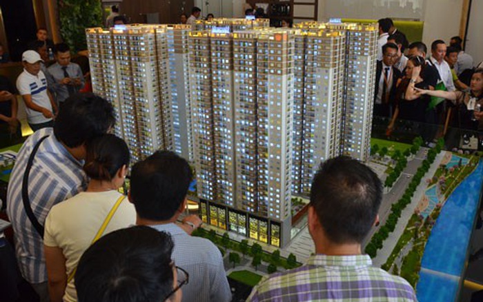 Khách hàng xem sa bàn một dự án bất động sản gồm nhiều tòa chung cư san sát nhau.