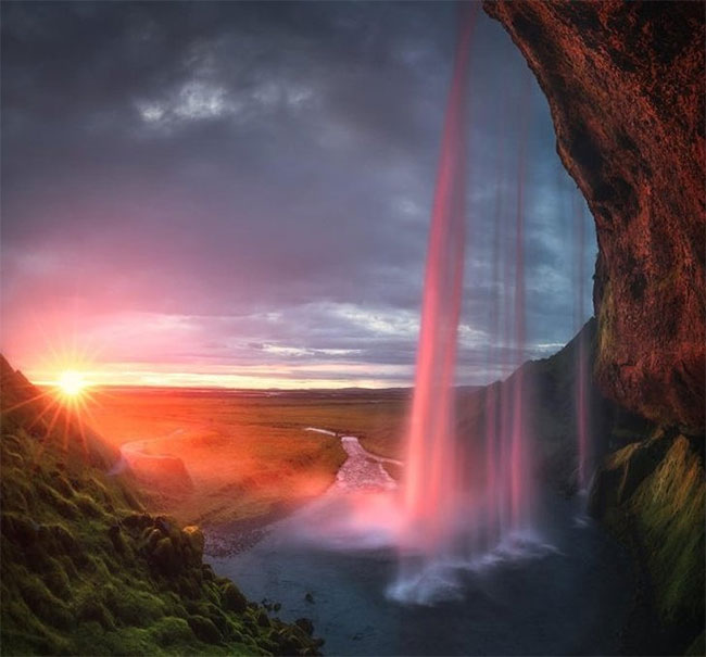 Hoàng hôn nửa đêm phản chiếu trong một thác nước ở Iceland