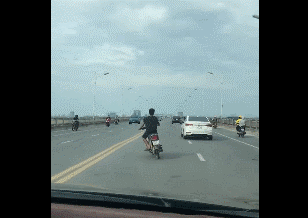 Nam thanh niên đầu trần lái xe máy đùa với tử thần