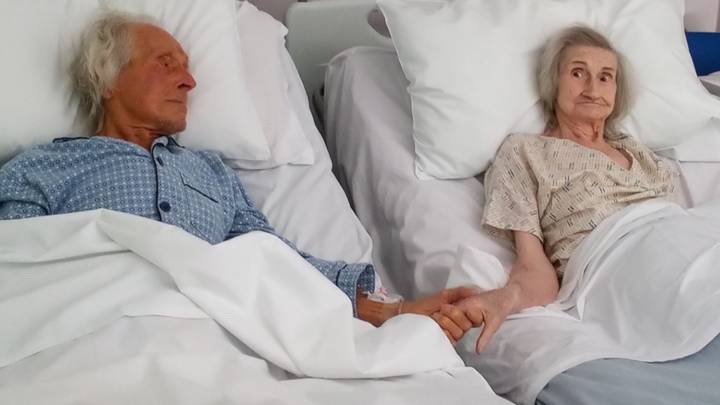 Một bức ảnh đầy tình cảm, hai người nắm tay nhau trên giường, tạo nên một không gian ấm áp và tràn đầy niềm yêu thương. Hãy xem bức ảnh này để cảm nhận được tình cảm đẹp và sự ấm áp gia đình.