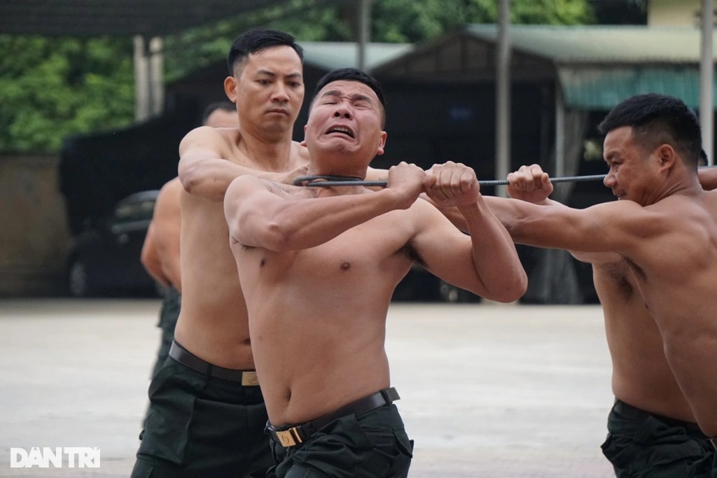 Xem chiến sĩ cảnh sát cơ động dùng răng kéo xe, đập đá trên bụng - 4