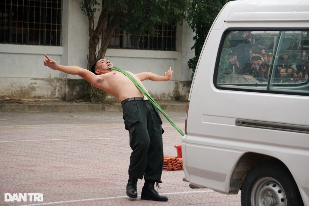 Xem chiến sĩ cảnh sát cơ động dùng răng kéo xe, đập đá trên bụng - 6