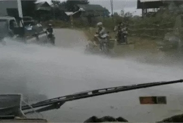 Gặp vòi nước phun trắng đường, tài xế ô tô che chắn cho người đi xe máy