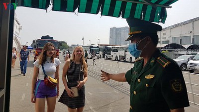 Tourists receive medical examination and masks upon arrival at Saigon port