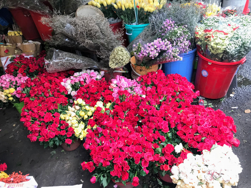 Chủ một shop hoa tên Tuấn – kinh doanh hoa lâu năm tại khu vực chợ này cho hay sở dĩ giá hoa hồng cao là do hoa anh lựa chọn từ trong bó lớn 50 bông, những bông đạt được chọn phải là loại to, đều, đẹp, không dập, héo,… hiện anh này bán với mức giá lẻ là 5.000 đồng/bông hồng đỏ, 8.000 đồng/bông loại hồng (màu hồng phấn, xanh nhạt,…). “Mức giá lẻ cao là do ngoài công lựa, tỉa lá và gai, thêm nhân công thì loại hồng chỗ shop bán chủ yếu là hàng tuyển, sẽ chưng được lâu, đẹp hơn các loại hoa bán bên trong chợ”, anh Tuấn cho hay.