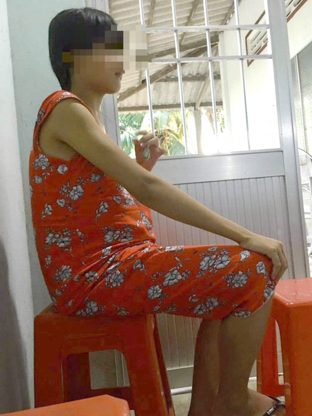 Người mẹ trẻ em K. thường ngồi tựa cửa, tay lần theo sợi dây chuyền…