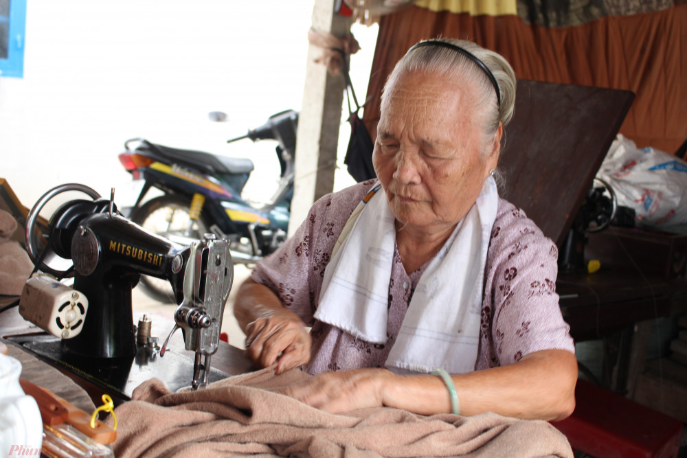 Mỗi ngày, cụ Vàng đều ra căn chòi bên cạnh nhà may chăn, quần áo tặng người nghèo