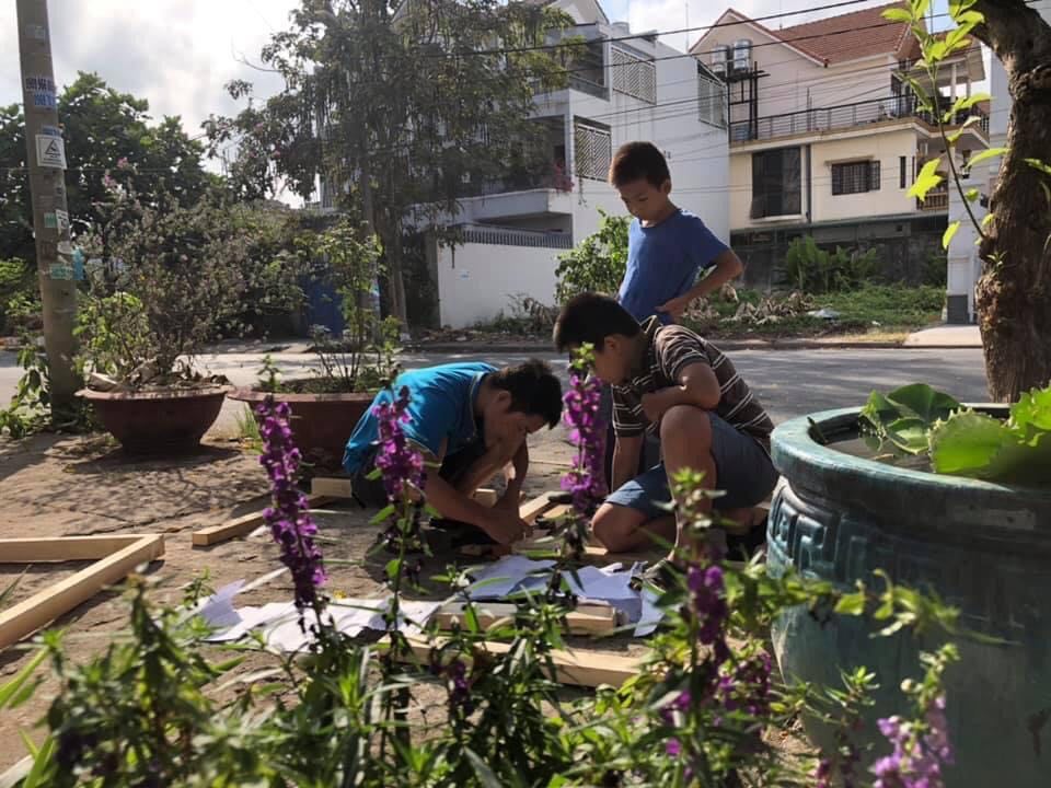 Chồng chị Hoa đang hướng dẫn 2 con cách đóng đinh (Ảnh nhân vật cung cấp)