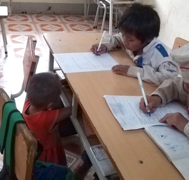 Cảnh anh chị học bài, em ngồi chơi đùa bên cạnh không quá xa lạ ở Trường Phổ thông dân tộc bán trú tiểu học Bắc Lý 1