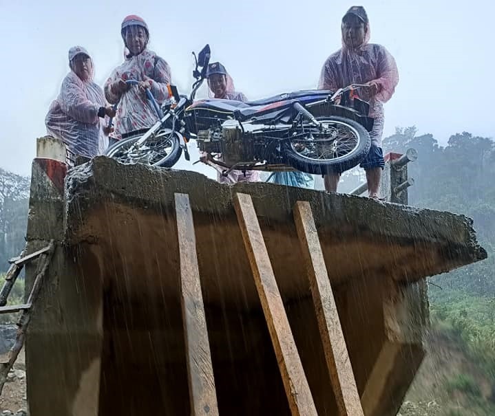 Nhóm người vùng cao dùng dây dù và vài thanh gỗ để kéo xe máy lên chiếc “cầu cụt” sau phút giây sinh tử. Ảnh: facebook Chip So