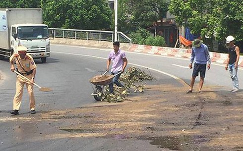 CSGT xử lý vết dầu loang giữa trời nắng 40 độ C - ảnh 2