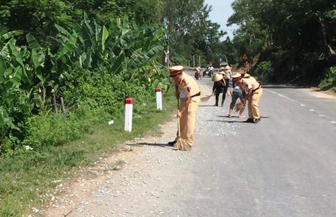 Nghệ An: CSGT dừng xe cùng người dân dọn đá dăm rơi trên quốc lộ - ảnh 1