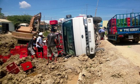 Lật xe tải chở bia, người dân giúp tài xế gom lại tài sản - ảnh 1