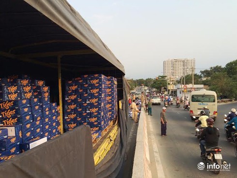 Người dân giúp tài xế xe tải gom hàng trăm thùng bia rơi xuống đường - ảnh 3