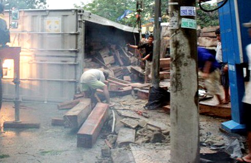 Huế: Xe container chở gỗ lật nhào giữa phố