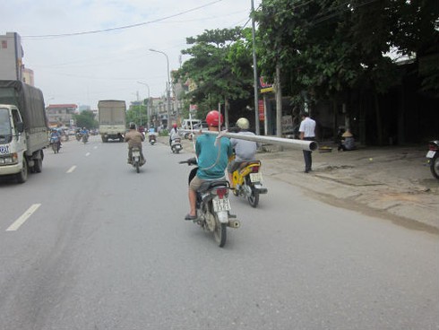 Vừa lái xe vừa ôm `vũ khí` băng băng giữa phố