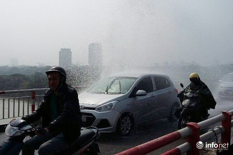 Vỡ đường ống nước, người dân mặc áo mưa đi qua cầu giữa trời nắng - ảnh 1