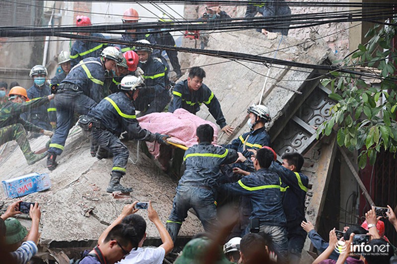Nạn nhân cuối cùng vụ sập nhà được đưa ra dưới cơn mưa to - ảnh 1