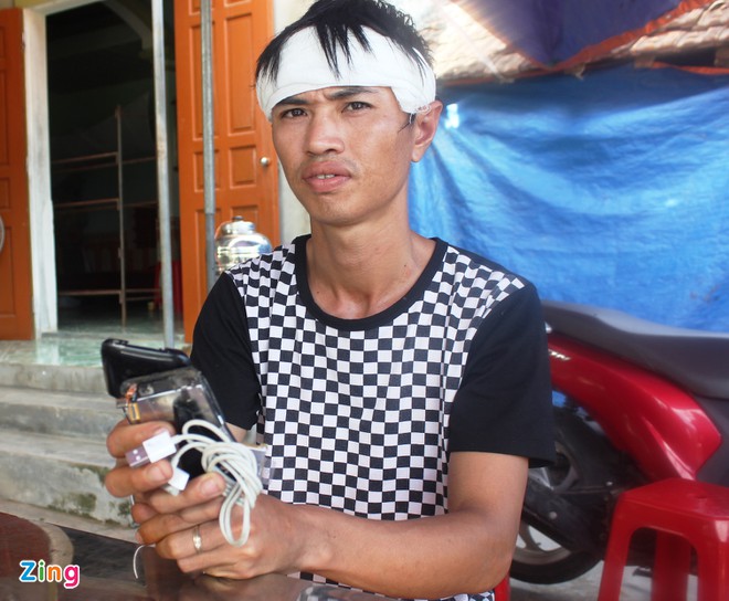 Anh Quân cầm trên tay chiếc ịhone 3 bị vỡ vụn. ẢNh: Phạm Hòa.