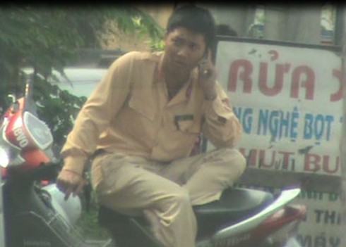 CSGT ngồi vắt vẻo yên xe máy, nghe điện thoại, bên vệ đường - ảnh 1