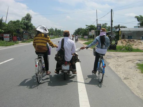 Xe máy vừa đi vừa đẩy xe đạp bị xử phạt như thế nào - ảnh 1