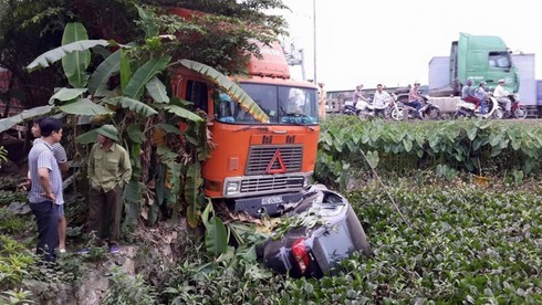 Ô tô biển xanh bị container húc văng xuống ao - ảnh 1