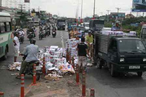 Xe tải bị ép ngã nhào, đổ hàng trăm thùng bia