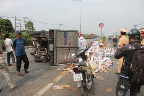 Xe tải bị ép ngã nhào, đổ hàng trăm thùng bia