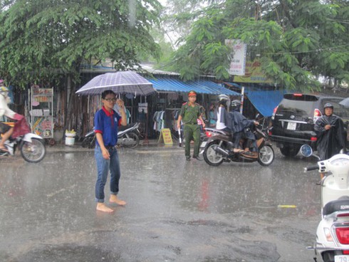 Xúc động cảnh tình nguyện viên vật lộn dưới mưa giúp thí sinh