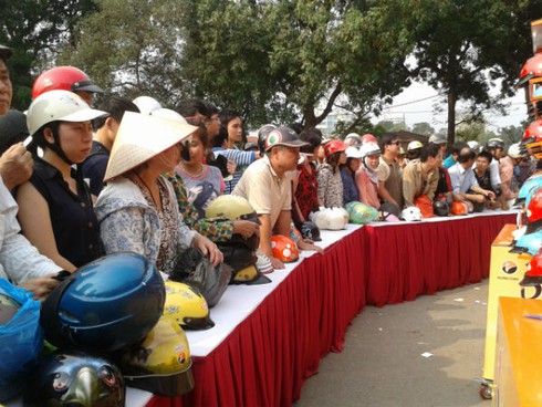 Hàng trăm người xếp hàng đội nắng đổi mũ bảo hiểm - ảnh 1