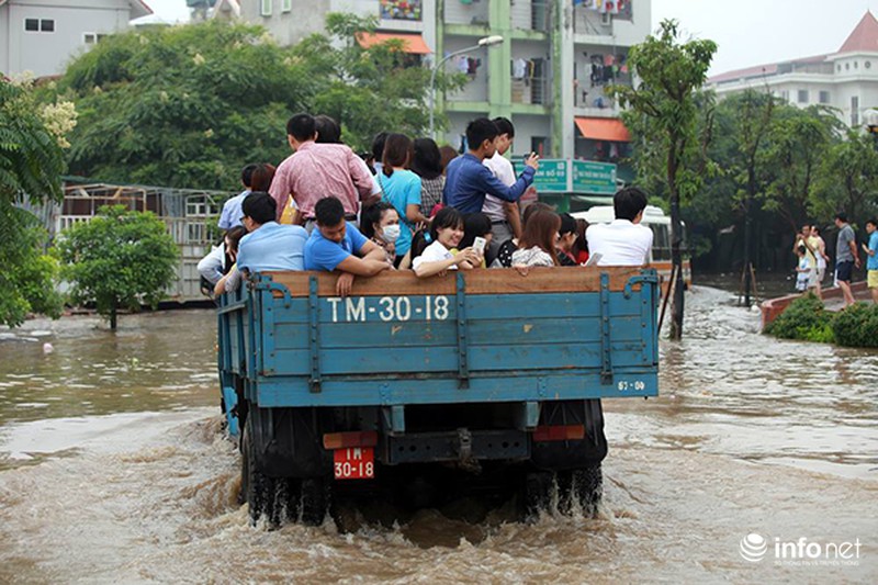 Giữa Hà Nội: Máy xúc đưa người dân qua chỗ ngập nước - ảnh 1