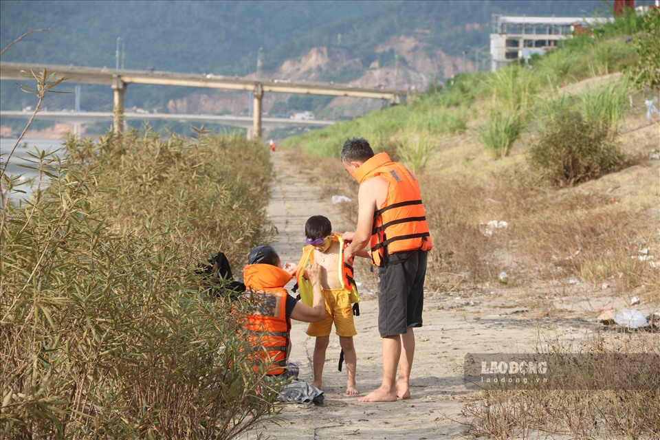 Từ già đến trẻ đều mang những vật dụng như áo phao, quần áo bơi để tắm mát.