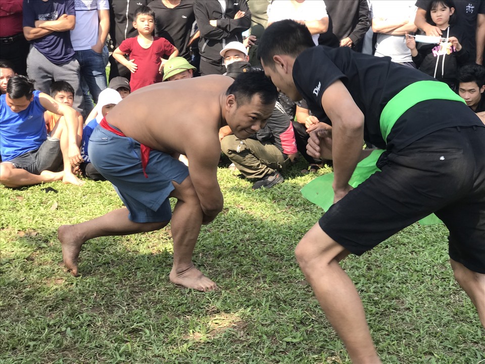 Hundreds of people in the sun watch the wrestling festival in the middle of the field in Duong Lam ancient village