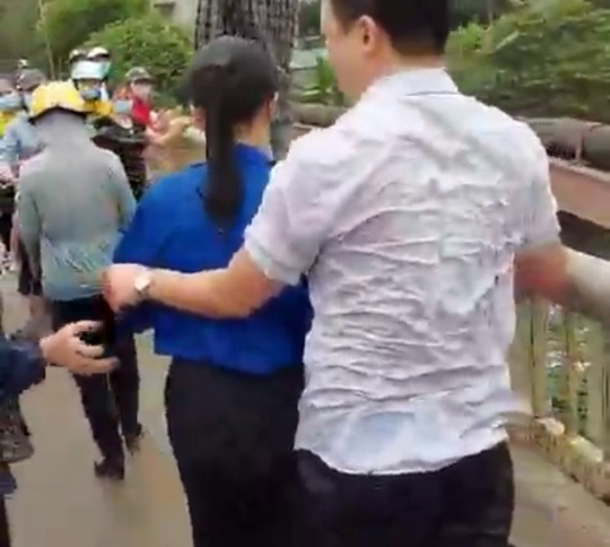 Anh Sinh (người mặc áo trắng) tại thời điểm nhảy xuống sông cứu cô gái trẻ lên bờ. Ảnh: Cắt từ Clip